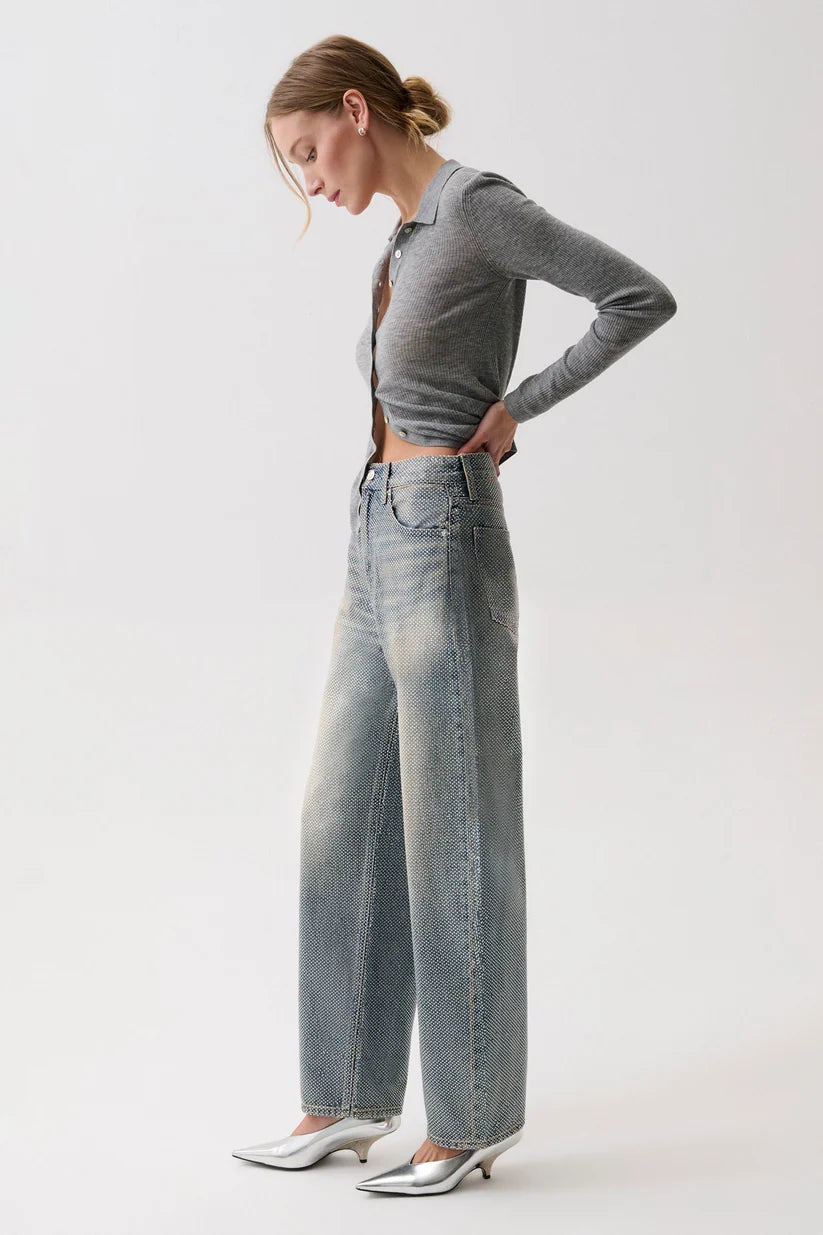 model wearing a rhinestone blue jean with a long sleeve grey top on a white background, side view
