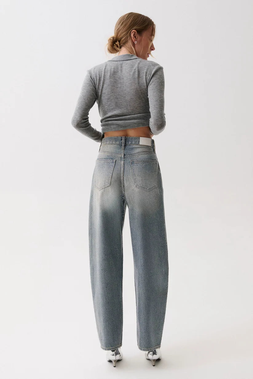 model wearing a rhinestone blue jean with a long sleeve grey top on a white background, back view