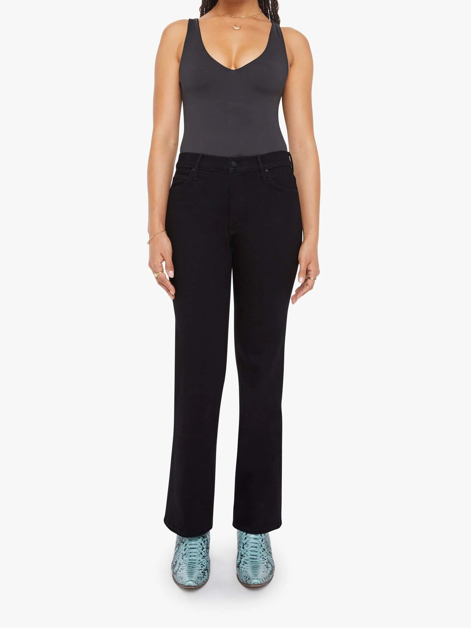 Woman wearing a black tank top and black pants on a white background