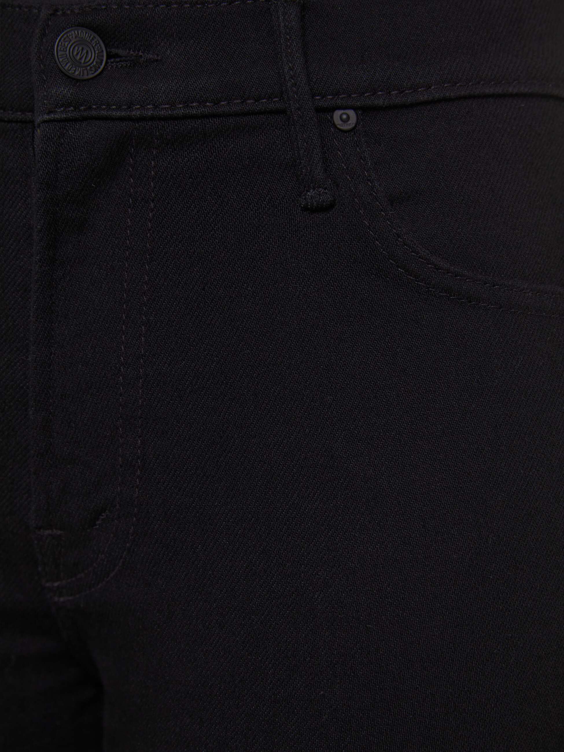 Close-up of black jeans with stitching details