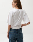 Person wearing a white t-shirt and blue jeans on a plain background