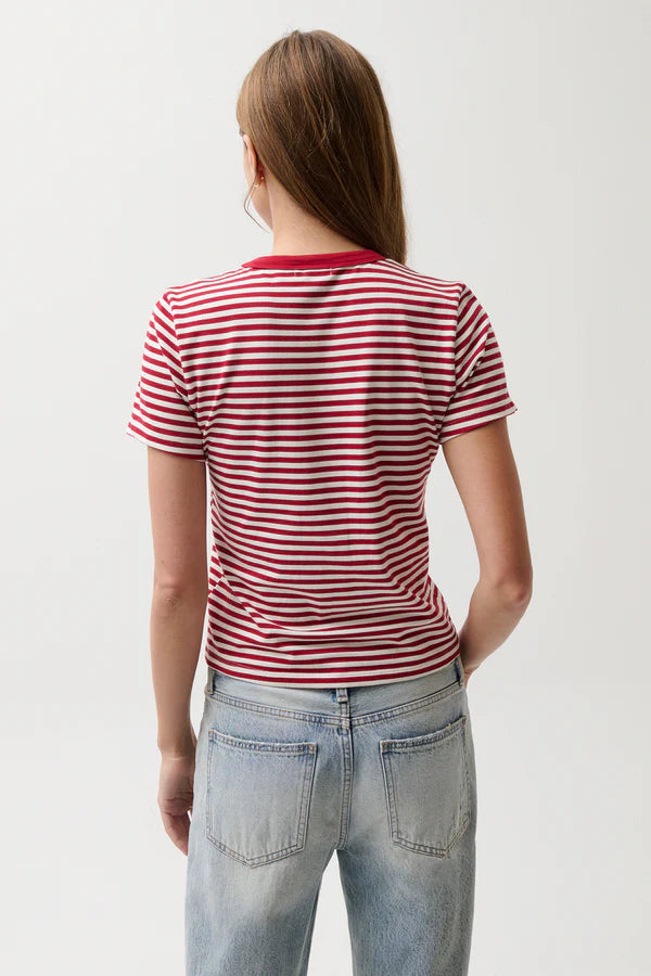 Person wearing a red and white striped shirt and light blue jeans on a plain background