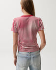 Person wearing a red and white striped shirt and light blue jeans on a plain background