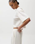 Person wearing a white outfit on a plain background