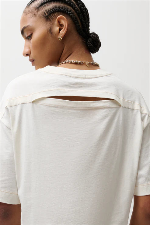 Person wearing a white blouse with a plain background, back