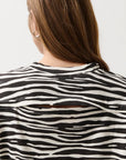 Person wearing a black and white zebra-striped shirt against a plain background