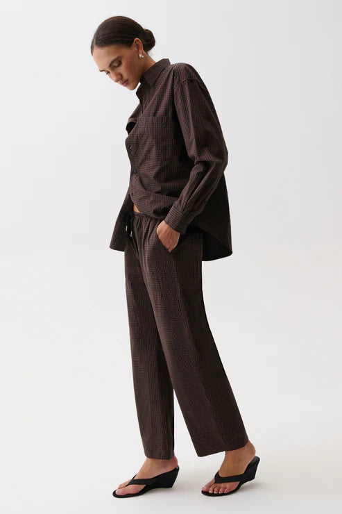 Person wearing a brown outfit on a white background