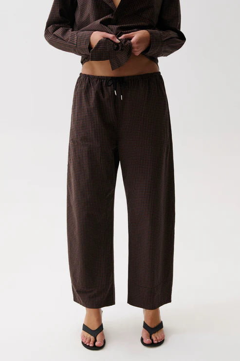 Model wearing brown theo pant on a white background