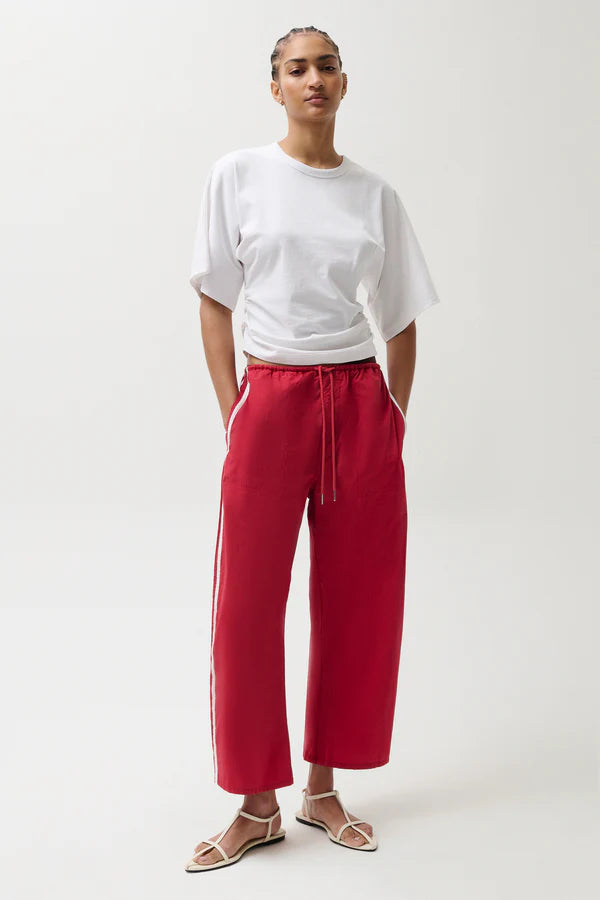 Person wearing a white t-shirt and red pants on a white background