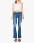Woman wearing blue jeans and a white top on a white background