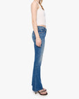 Woman wearing blue flared jeans and a white top on a white background