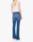 Woman wearing blue jeans and a white top on a white background