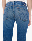 Blue jeans with a brand logo on the back pocket against a white background