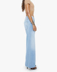 Woman wearing a beige top and light blue jeans on a white background