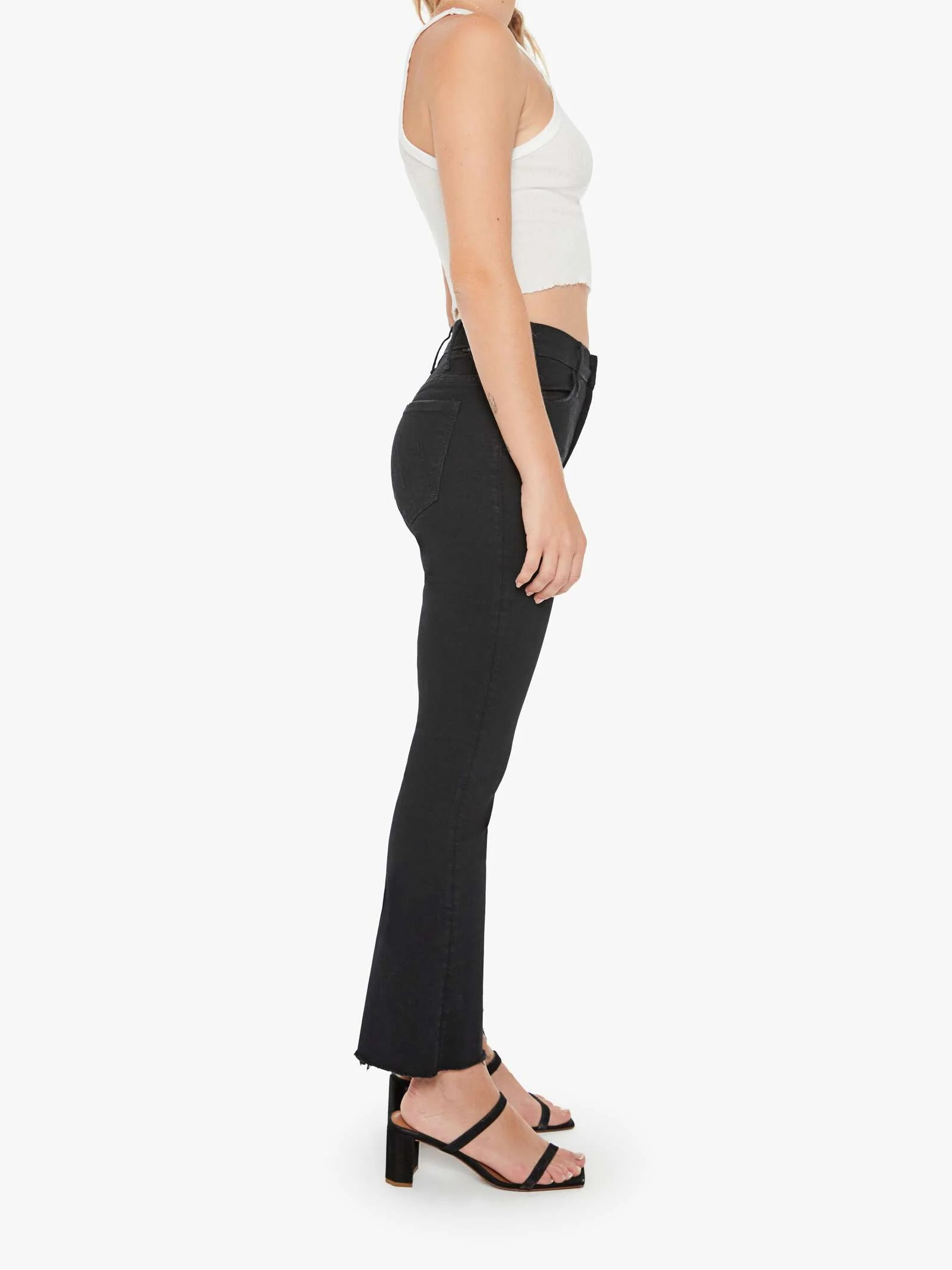 Woman wearing a white top and black pants on a white background