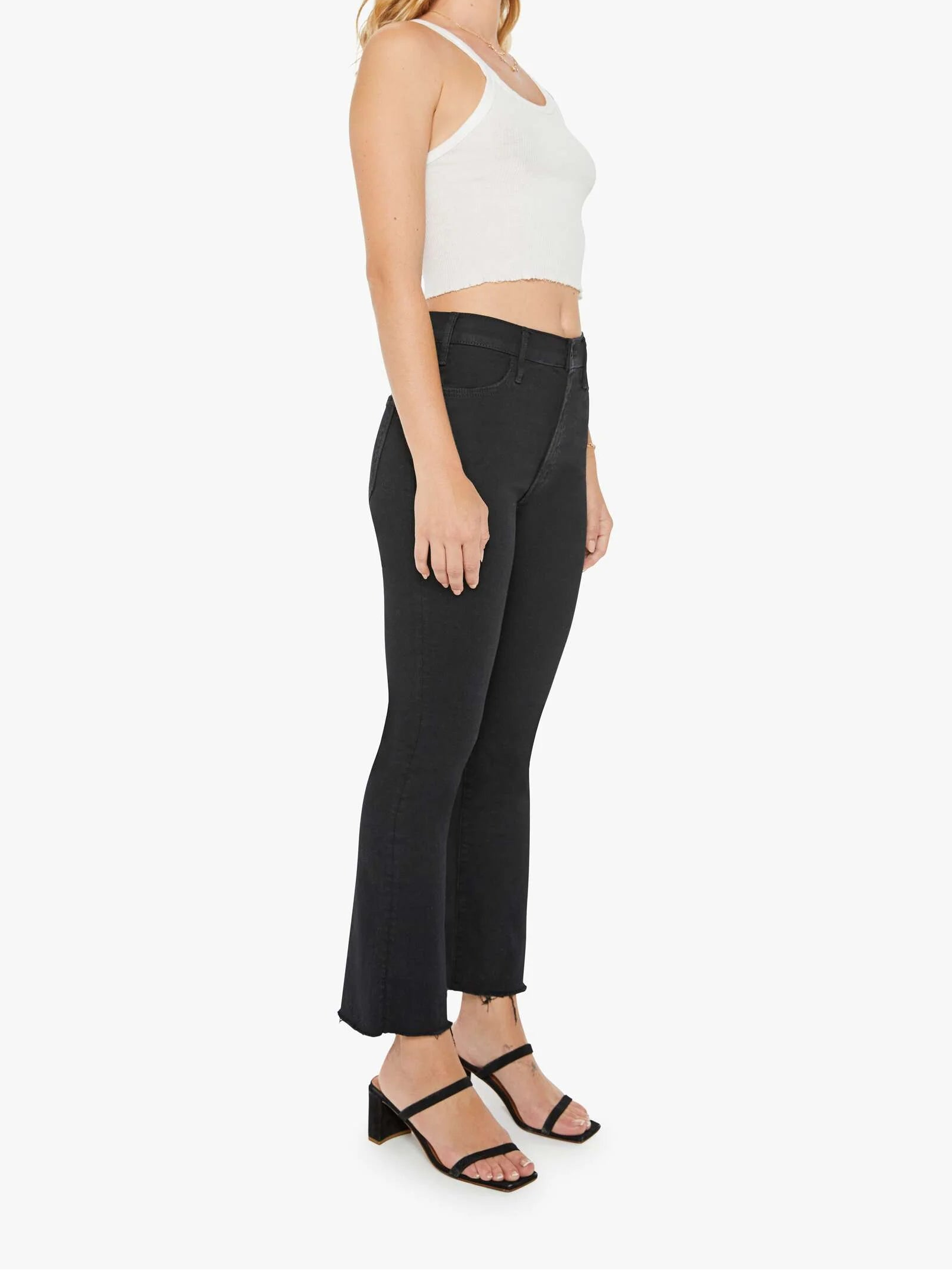 Woman wearing a white top and black pants on a white background