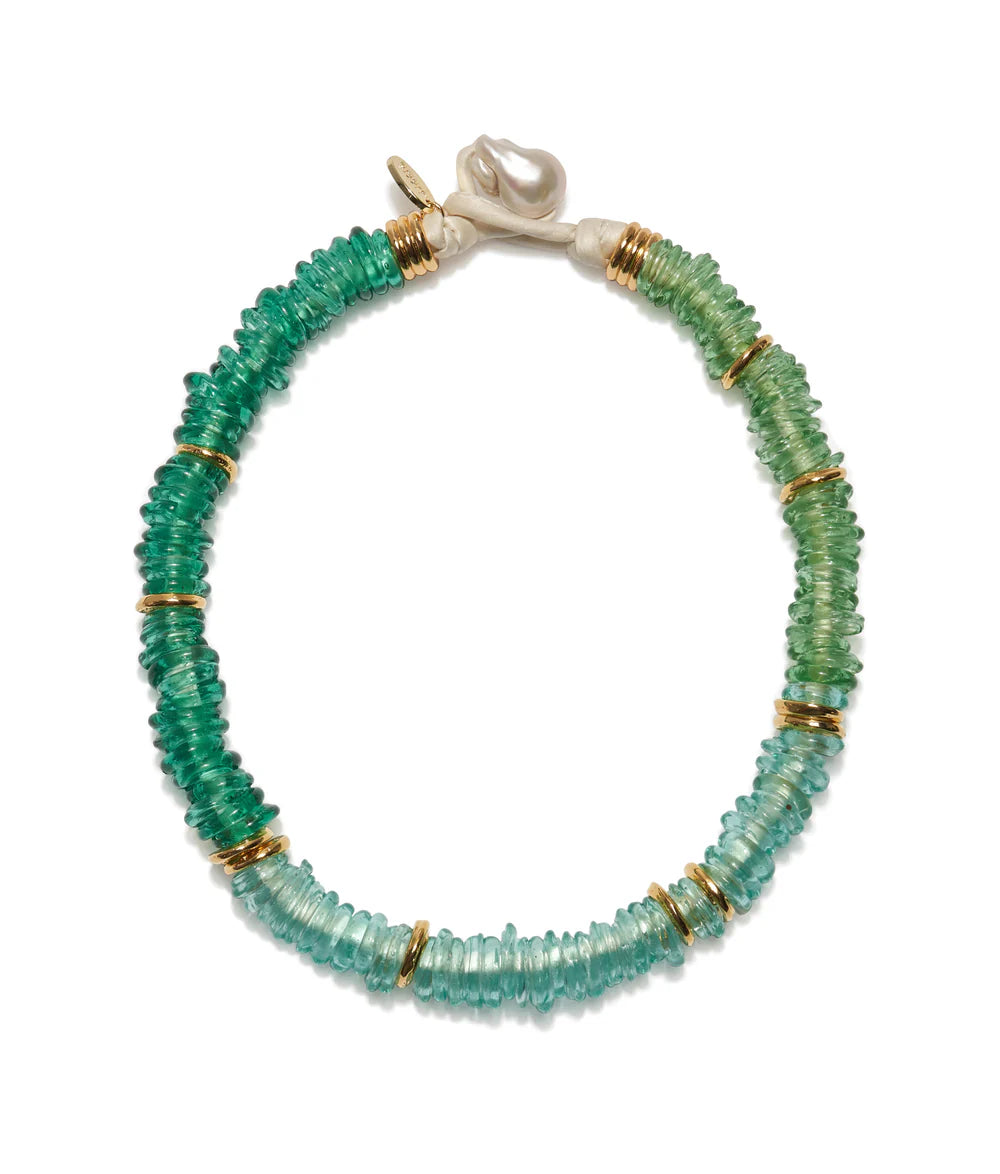 Green beaded bracelet with gold accents on a white background