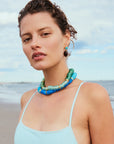 Woman wearing a colorful beaded necklace on a beach
