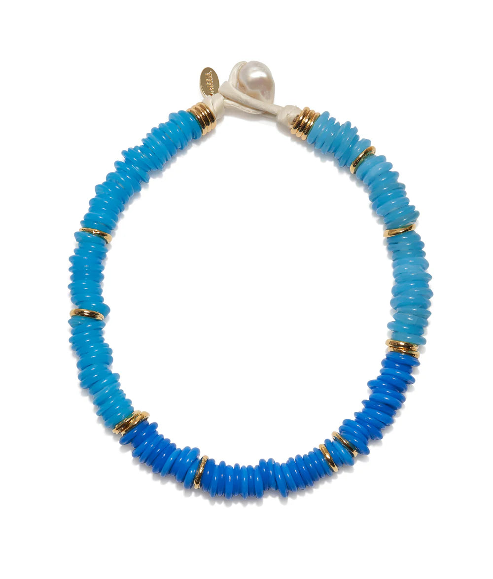 Blue beaded necklace with gold accents on a white background