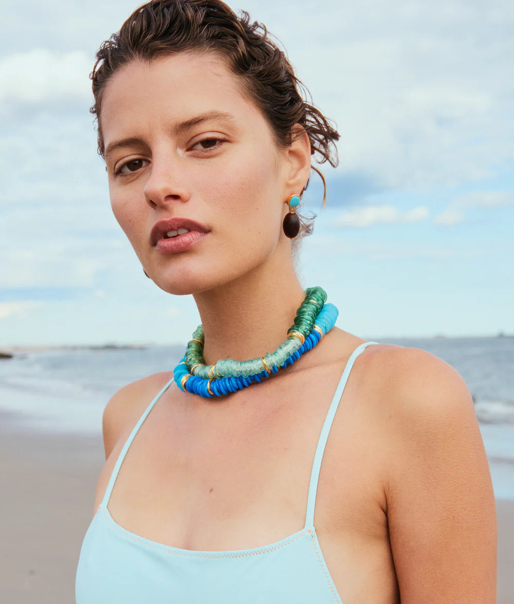 Woman wearing a colorful beaded necklace on a beach