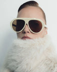 model wearing ivory sunglasses with a fur collar on a white background 