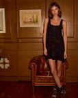 Nadia Dress farther back front view with model in front of wooden wall