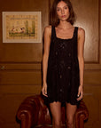 Nadia Dress front view with model in front of wooden wall