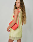 Annina Dress back/side view. Midi Sac Bright Poppy Woven Diagonal on model's shoulder, side view