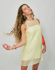 Woman wearing a light yellow dress with a red bag on a plain background with Josefina Earrings