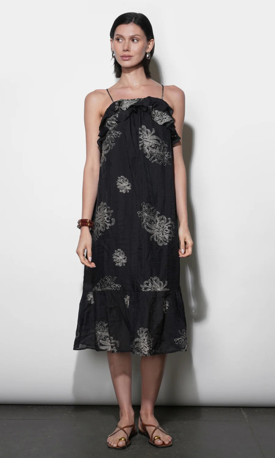 model wearing the Paige Layered Ruffle Midi Dress with strappy sandals on a white background, front 