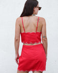 Woman wearing a red outfit with scalloped edges, back