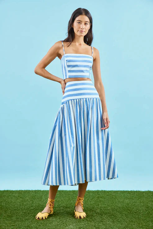 Woman wearing a blue and white striped outfit against a blue background