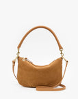 A tan suede crescent-shaped shoulder bag with a matching top handle and a detachable shoulder strap, accented with gold-tone hardware, shown on a plain white background.