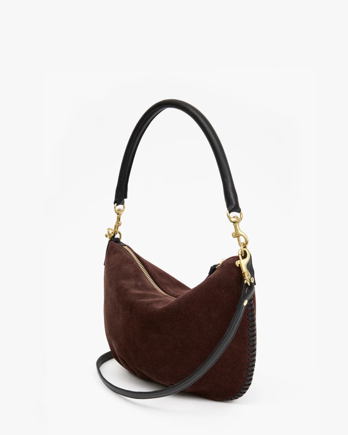 A dark brown suede crescent-shaped shoulder bag with a black leather handle and a black braided detail on the side, accented by gold-tone hardware.
