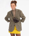 model wearing a houndstooth blazer and cross body mahogany bag