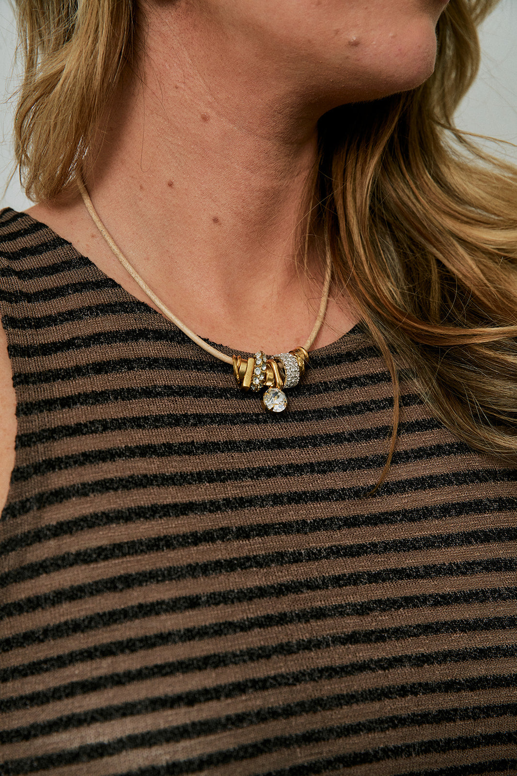 Desta Necklace close up against striped dress