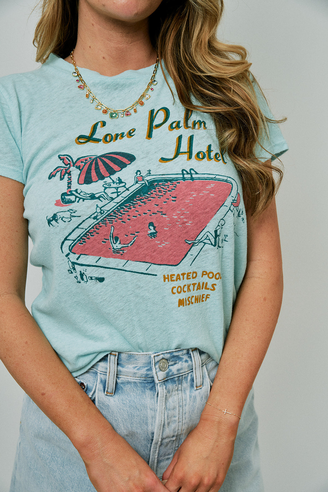 Person wearing a light blue t-shirt with a graphic design and text.