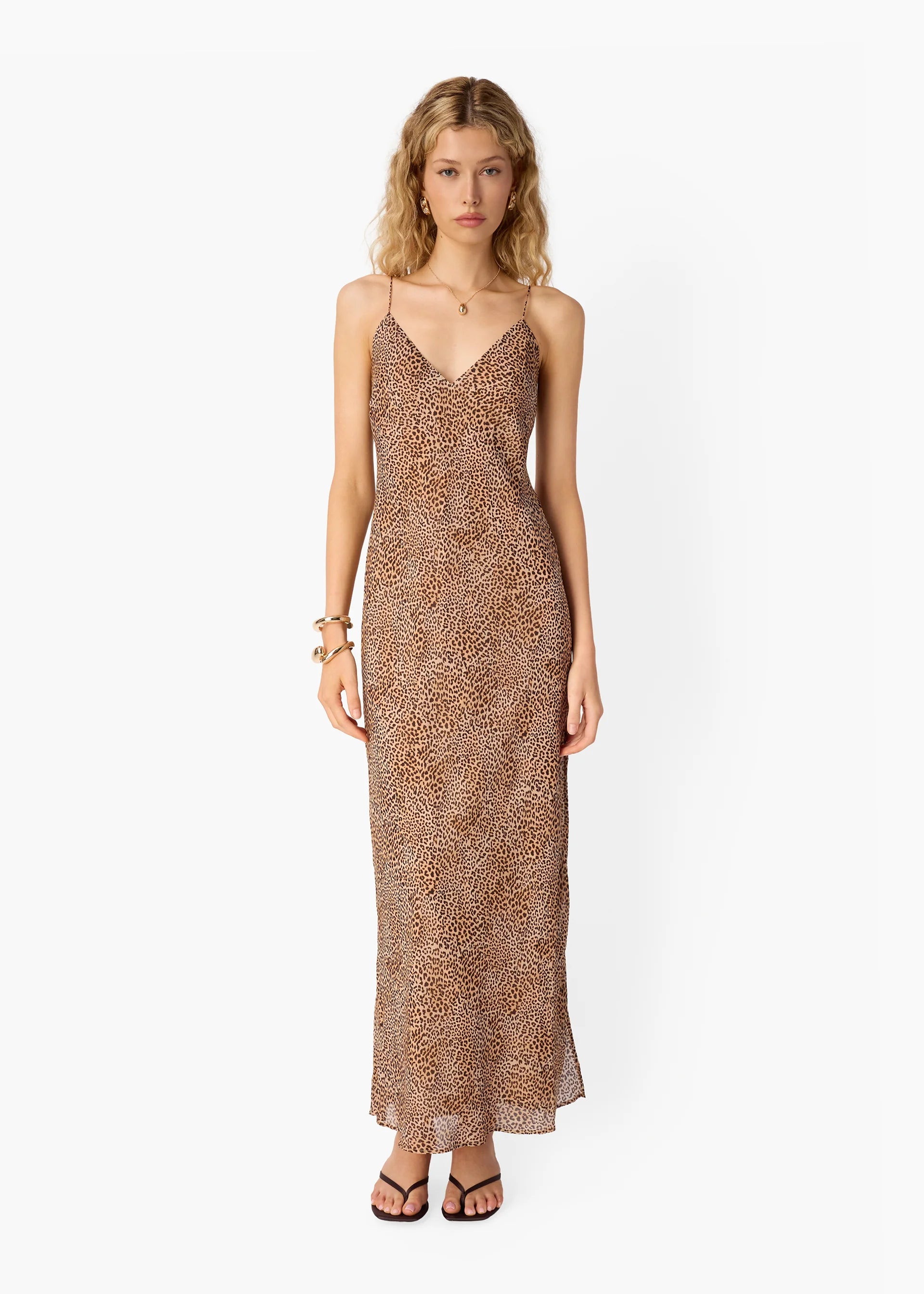 Woman wearing a long, patterned dress on a white background