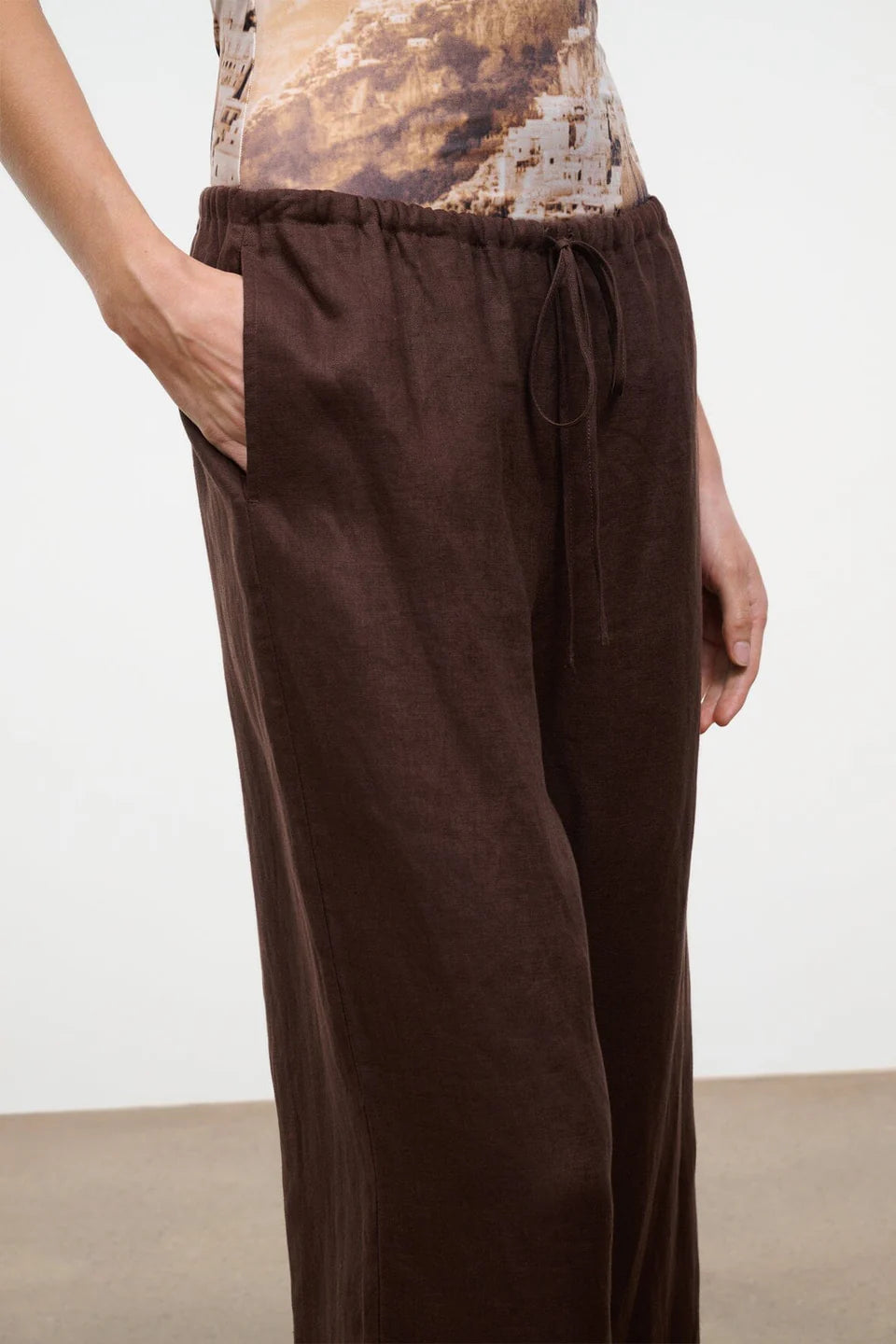 Brown pants worn by a person on a plain background