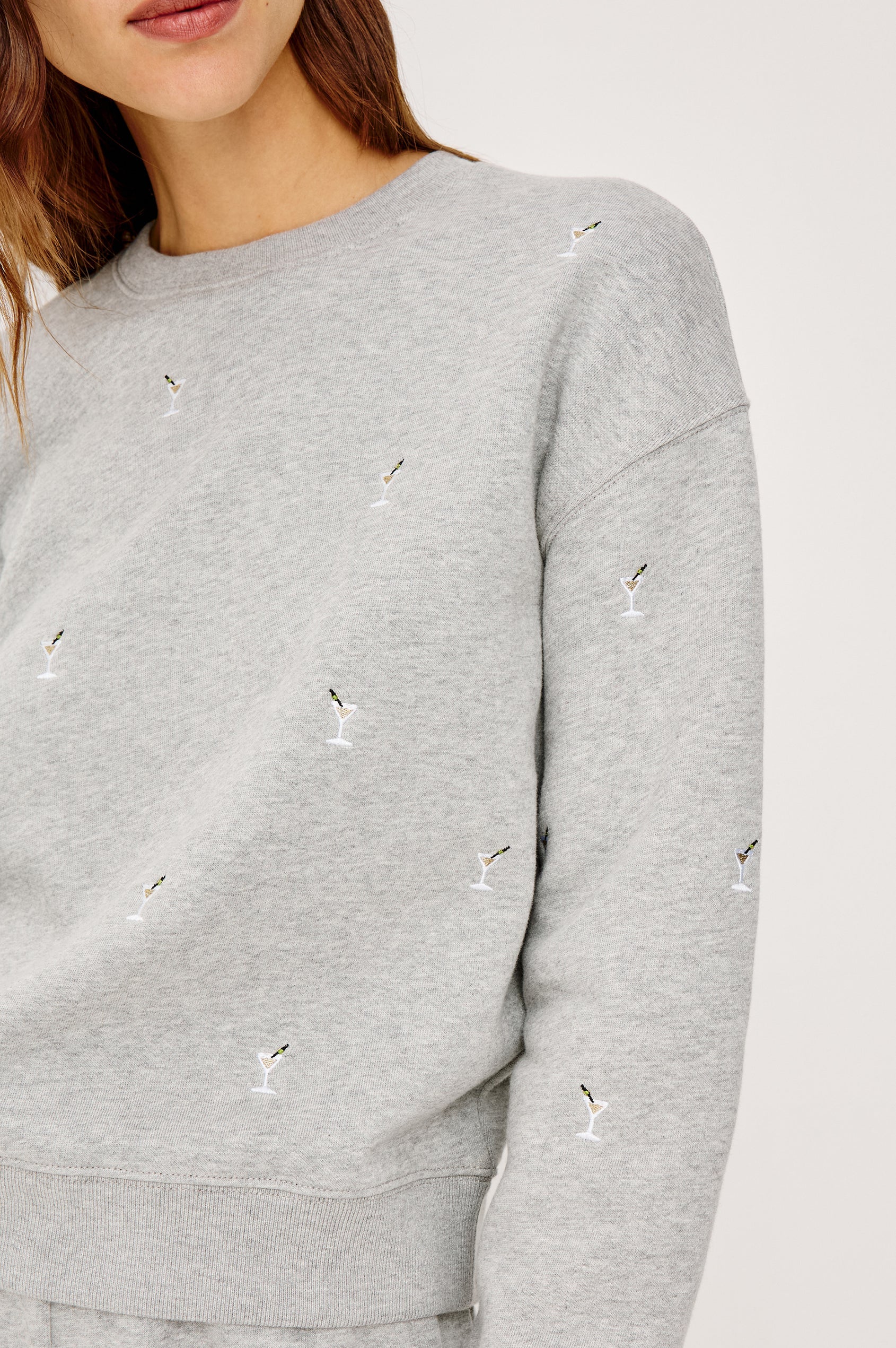 Gray sweatshirt with small martini embroidery on a light gray background