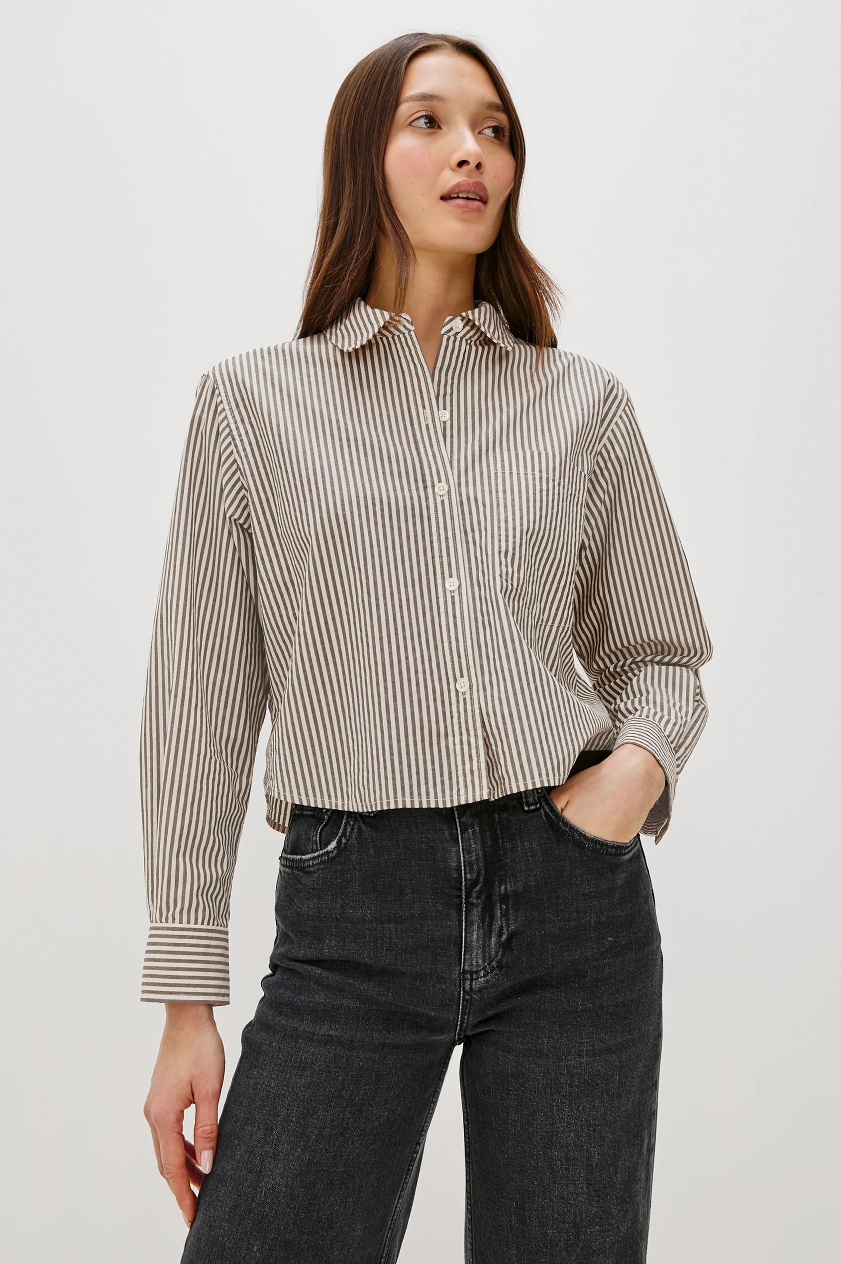 Woman wearing a striped shirt and black jeans against a white background front view