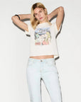 Woman wearing a graphic t-shirt and light blue jeans on a white background