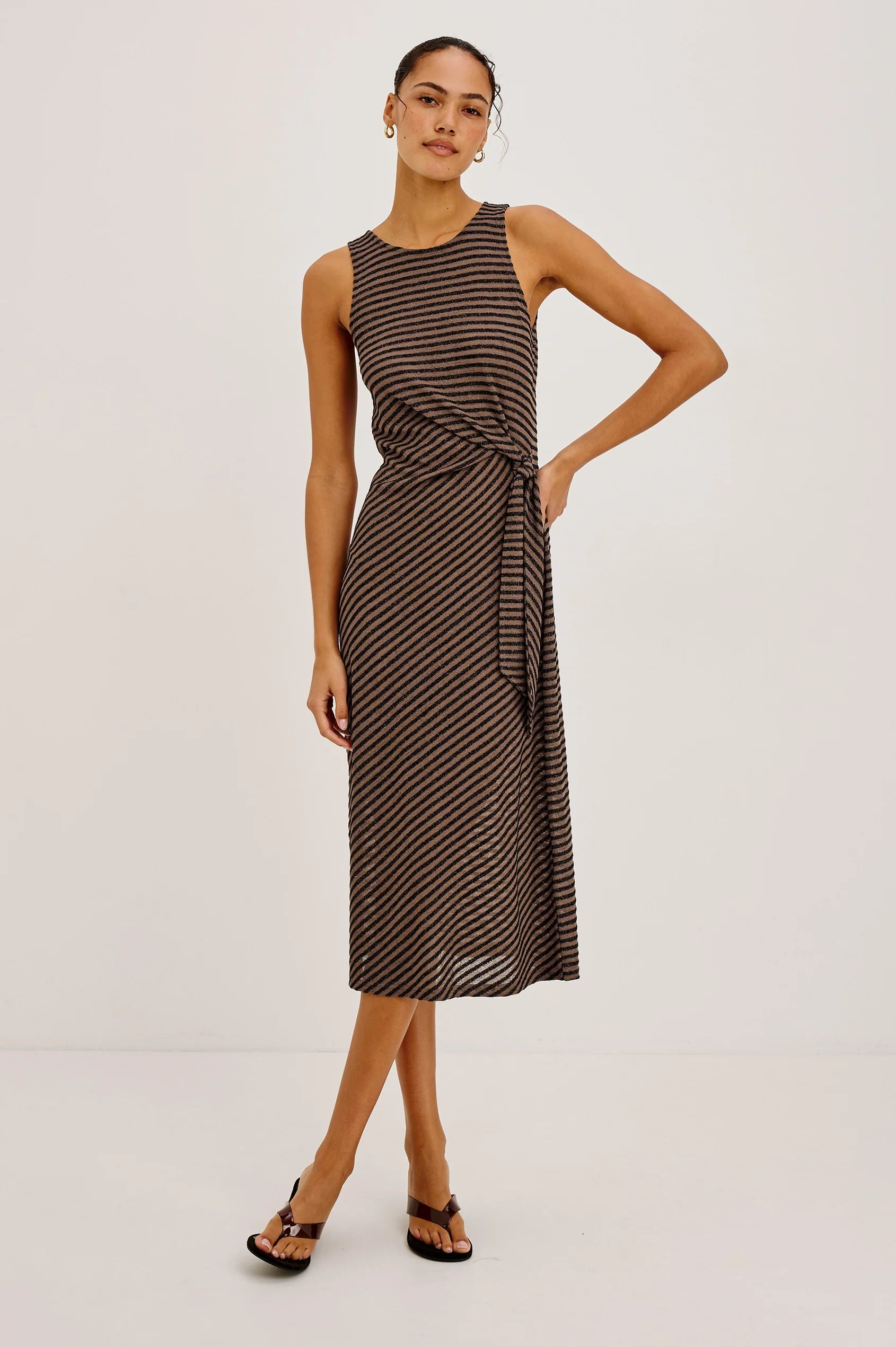 Woman wearing a striped dress on a plain background