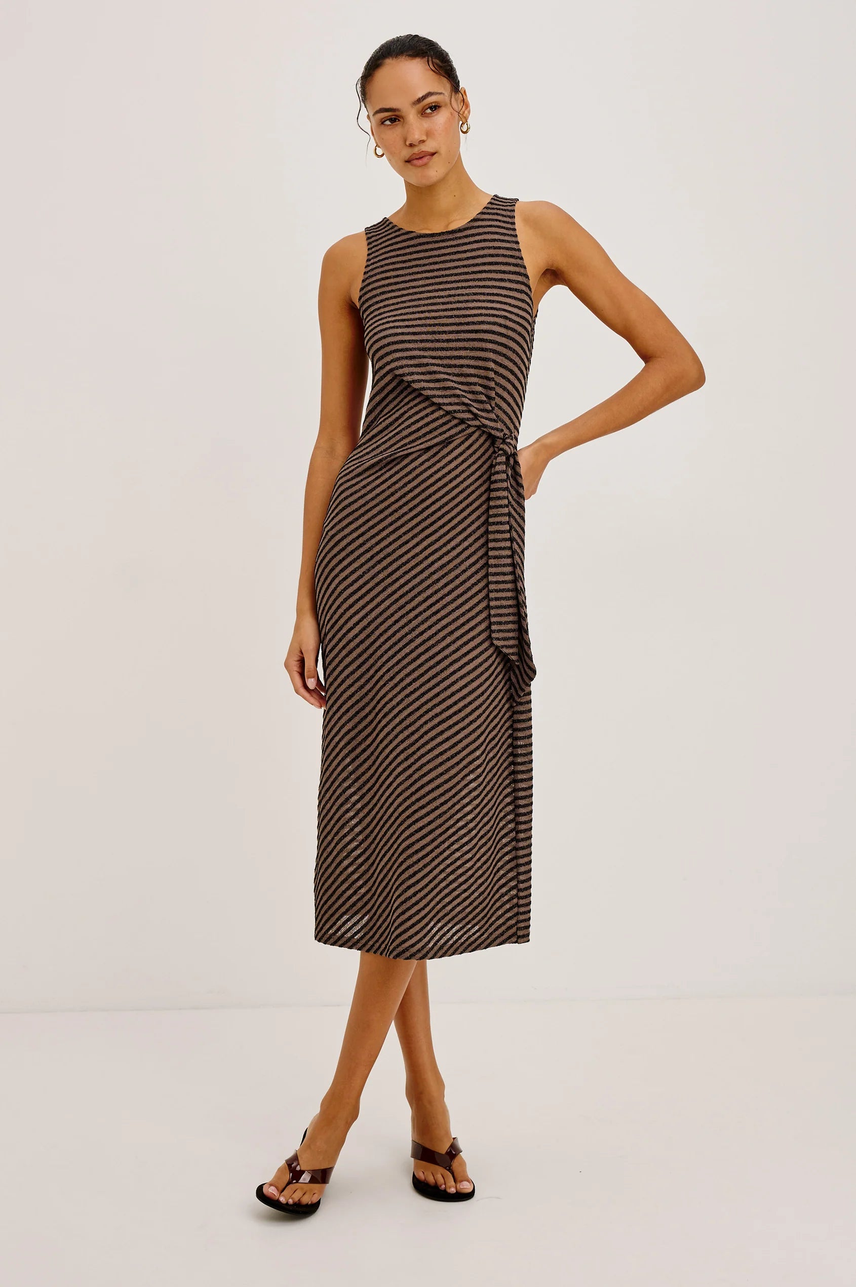 Woman wearing a brown and black striped dress on a white background