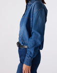 Person wearing a blue denim jumpsuit on a white background