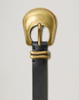 Black leather belt with a gold buckle on a light gray background