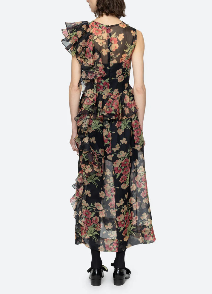 Woman wearing a floral dress with ruffled sleeves on a white background