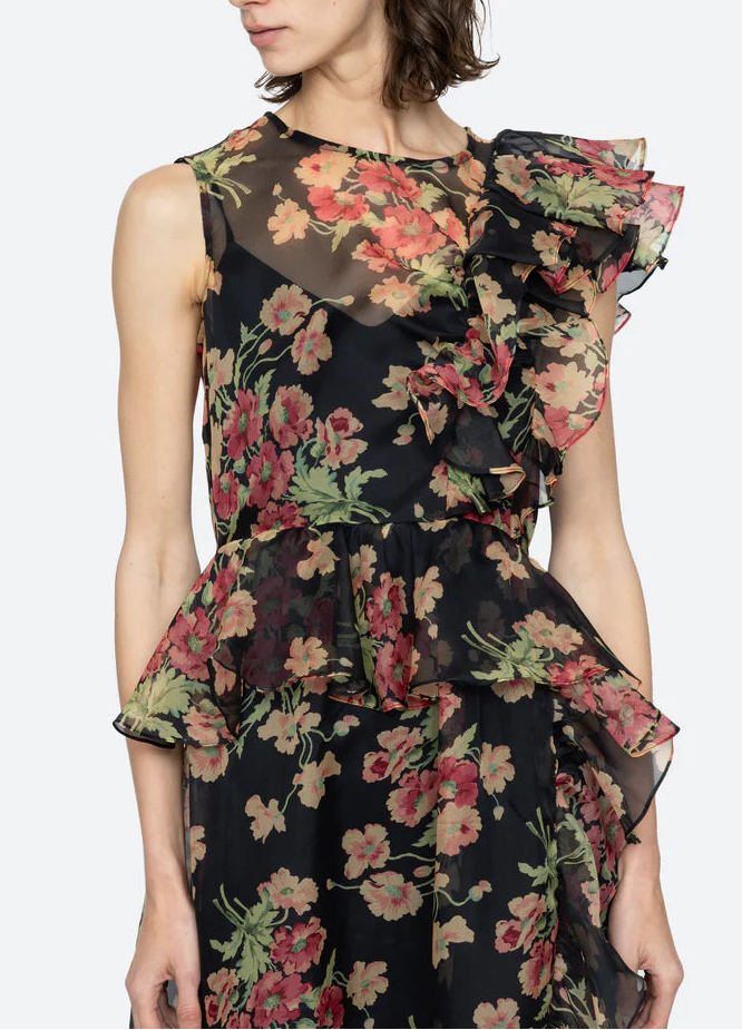 Woman wearing a floral dress with ruffled sleeves on a white background