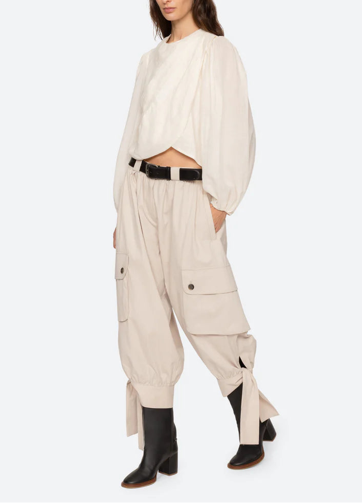 Woman wearing a beige outfit with a white background