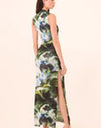 Woman wearing a floral dress with a high slit on a beige background